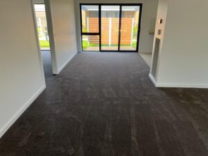 New charcoal carpet installed in a living room with sliding doors to the garden