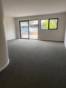 Grey carpet installed in a living room with garden views