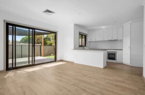 Light laminate flooring in an open plan kitchen and living space