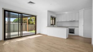 Light laminate flooring in an open plan kitchen and living space