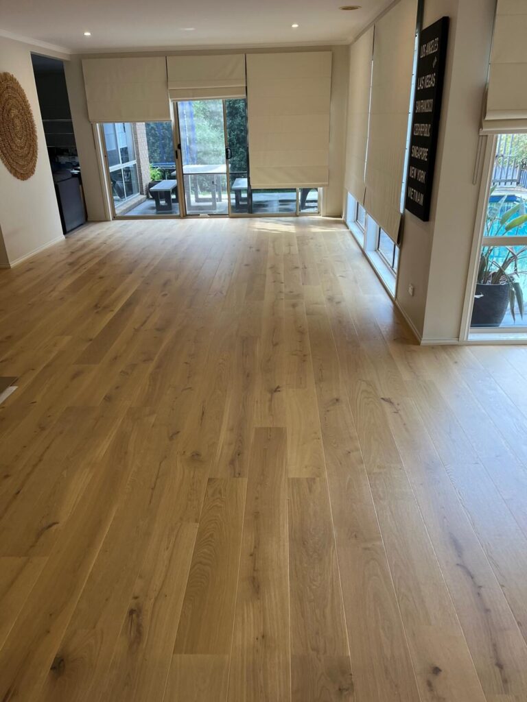 Wide plank engineered oak flooring through a hallway into a living room