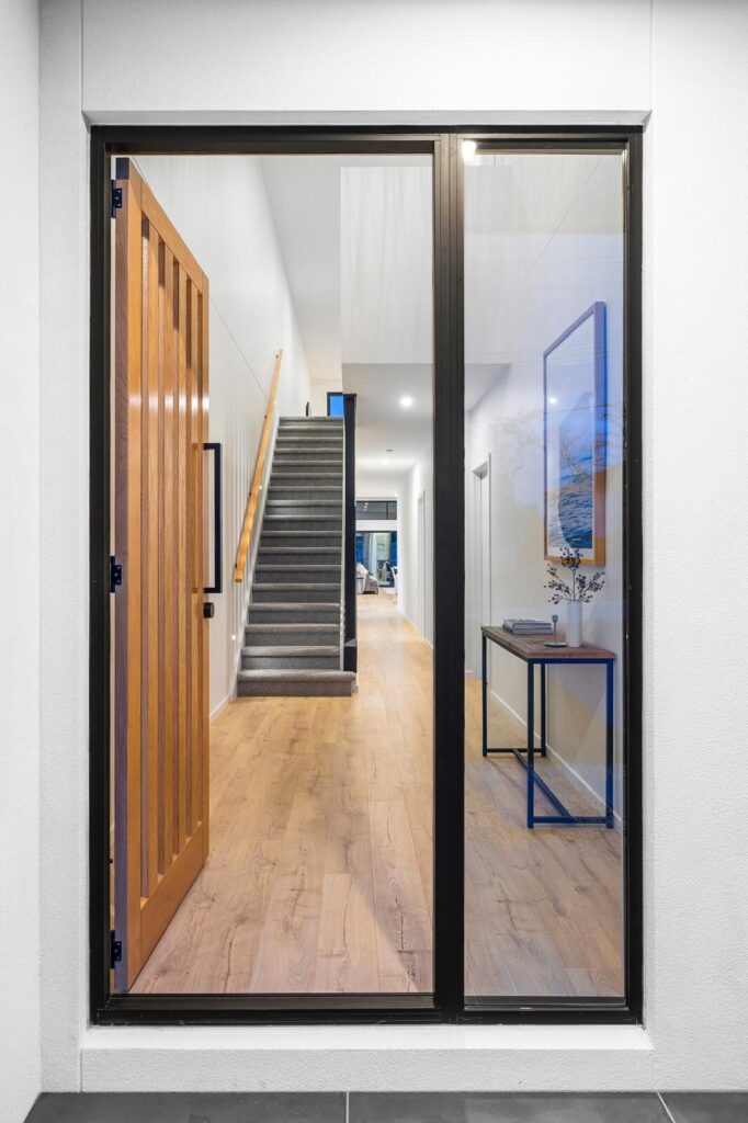 Timber flooring visible through glass doors into a hallway and staircase