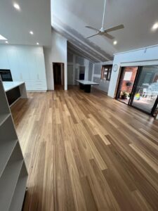 Timber flooring through a large open plan living area with raked ceilings